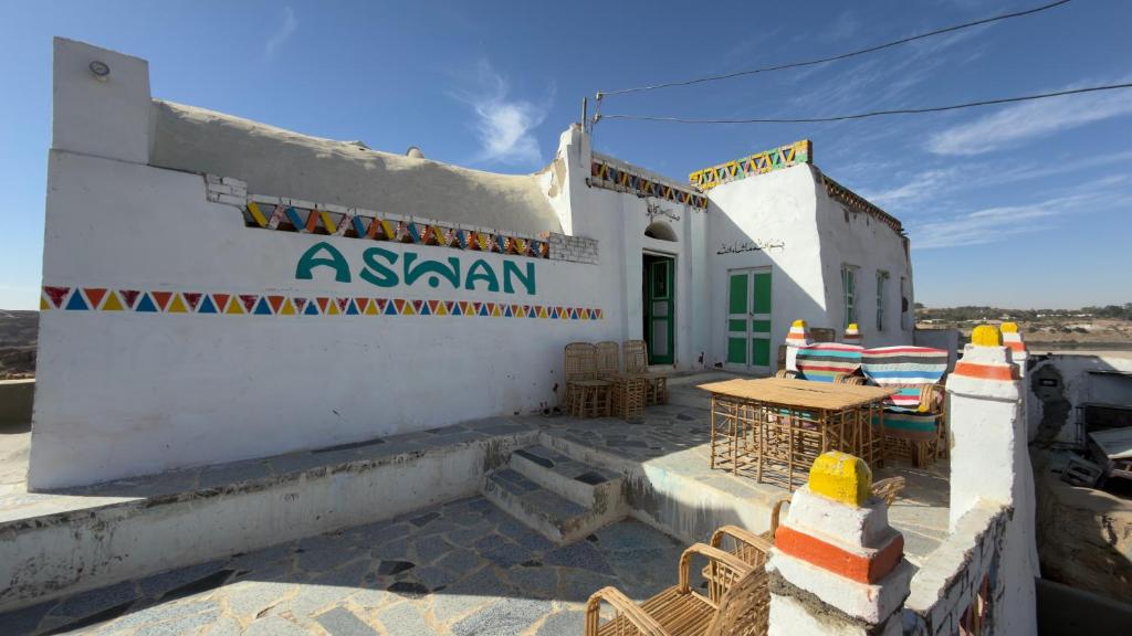 a white building with a table in front of it at Safeya Kato in Jazīrat ‘Awwāḑ