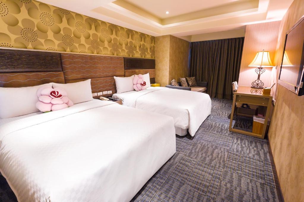 two beds with hello kitty pillows in a hotel room at Han She Hotel in Taipei