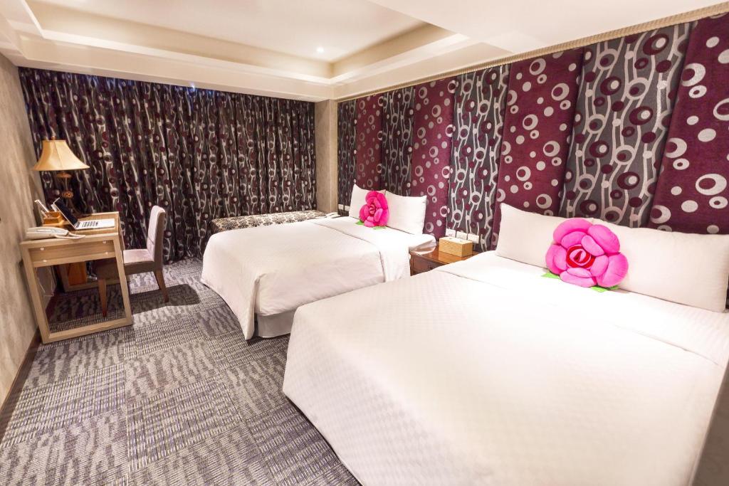 a hotel room with two beds and pink flowers on the walls at Han She Hotel in Taipei