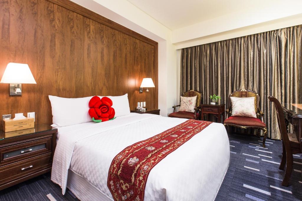 a hotel room with a bed with a red stuffed animal on it at Han She Hotel in Taipei