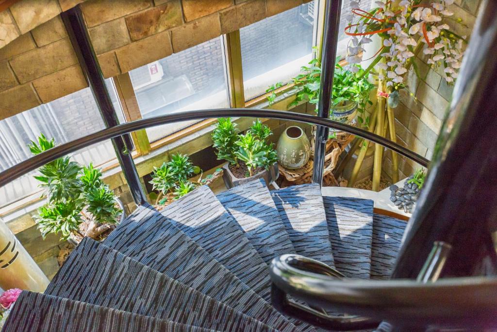 a balcony with a chair and a bunch of plants at Han She Hotel in Taipei