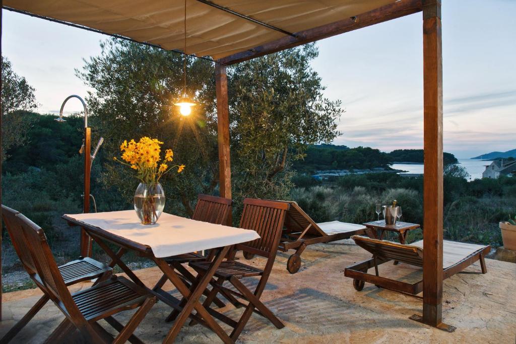 a table and chairs on a patio with a view at Robinson House Nicolina in Hvar