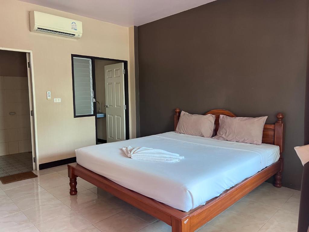 a bedroom with a bed with white sheets and pillows at โรงแรมสิริพรชัย in Takua Pa