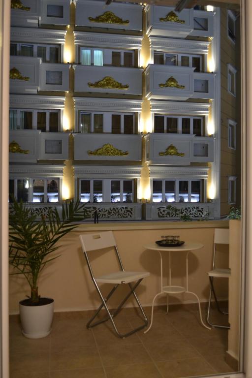 a room with a table and chairs in front of a building at Lazarus Apartment in Skopje