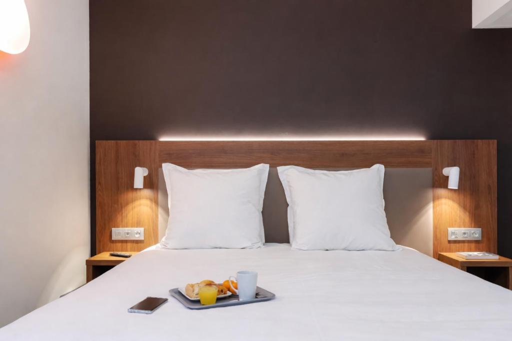 a hotel room with a bed with a tray of food on it at Campanile Epinal Centre - Gare in Épinal
