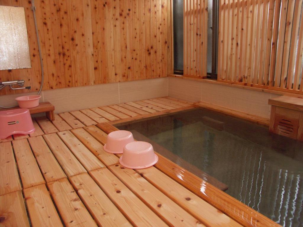 a hot tub in a wooden room with a wooden floor at 伊藤屋 in Zaō Onsen