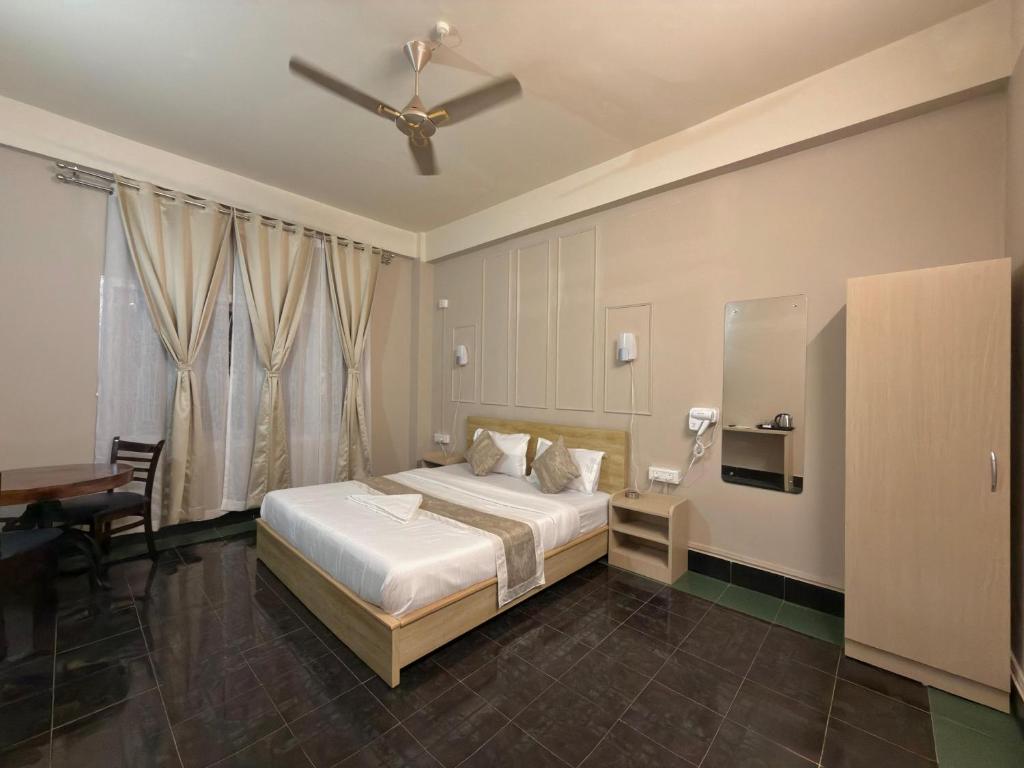 a bedroom with a bed and a ceiling fan at Restel Guest House in Guwahati