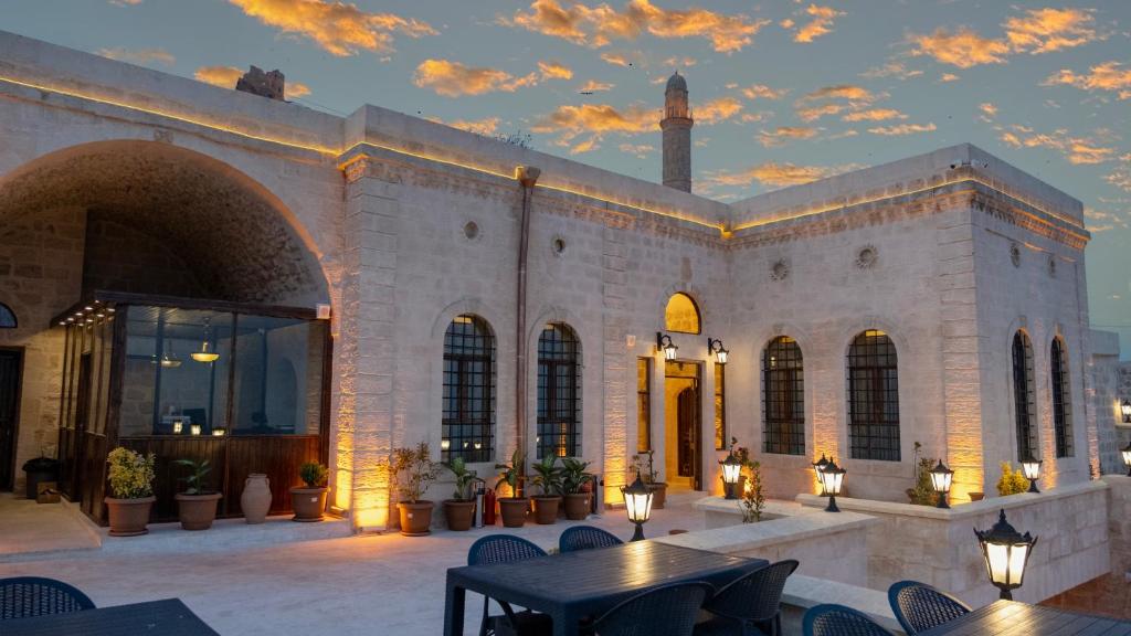 a building with a patio with tables and chairs at Vezir Konağı Hotel in Mardin