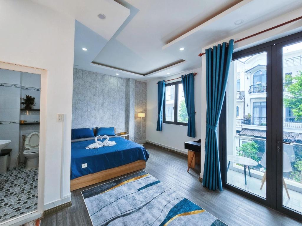 a bedroom with a blue bed and a balcony at Miha Villa 3 - House in Can Tho in Can Tho