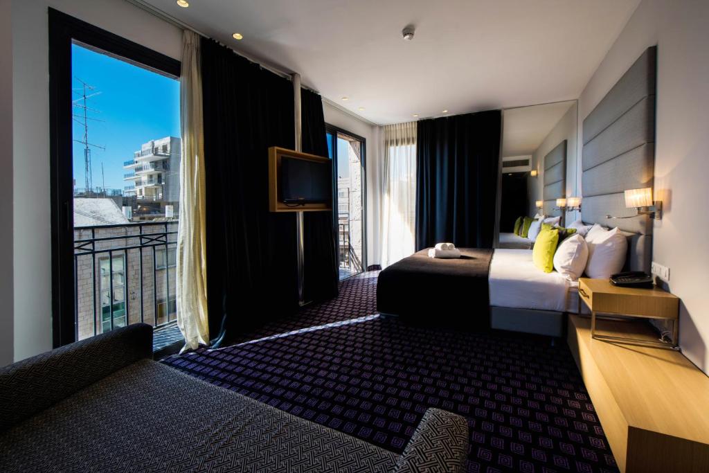 um quarto de hotel com uma cama e uma varanda em Eyal Hotel by Smart Hotels em Jerusalém