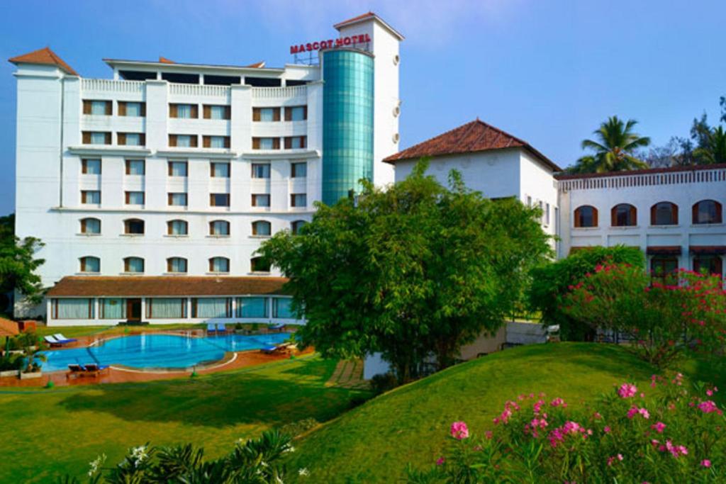 um hotel com piscina em frente a um edifício em The Mascot Hotel - A Heritage Living Experience em Trivandrum