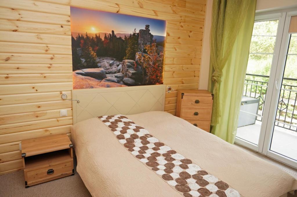 シュクラルスカ・ポレンバにあるApartament Cristalのベッドルーム1室(ベッド1台付)が備わります。壁に絵が飾られています。