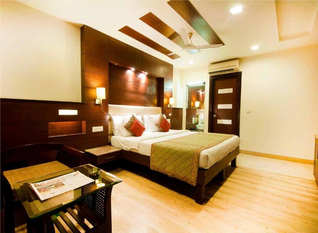 Habitación de hotel con cama y mesa en Hotel Amaltas International - Delhi-16, en Nueva Delhi