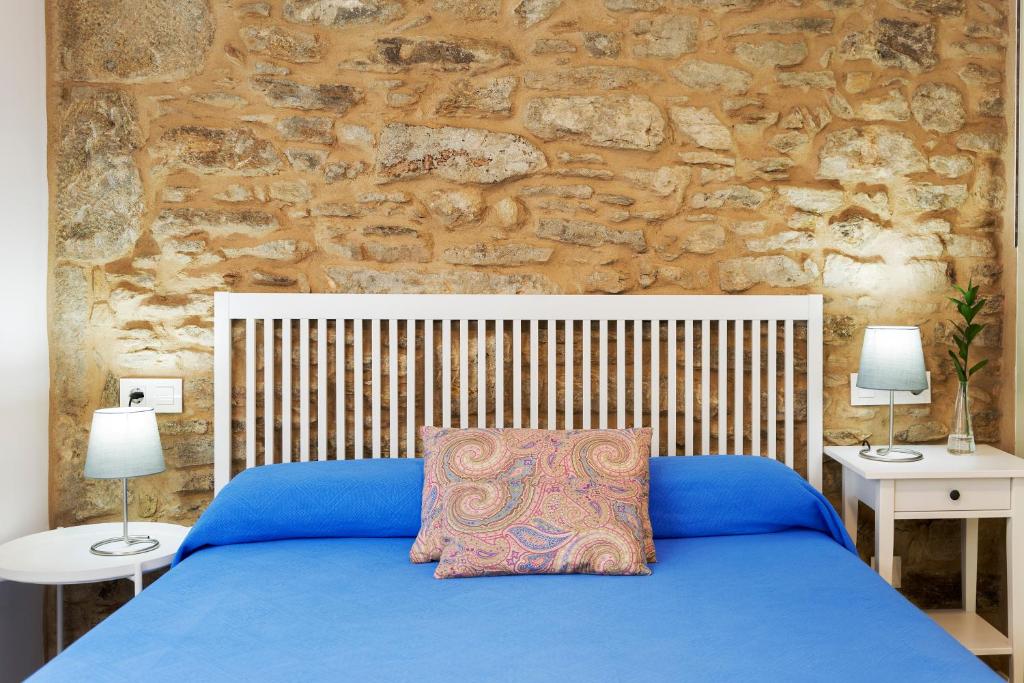 a bedroom with a blue bed with two night stands at Pensión Rua Nova in Santiago de Compostela