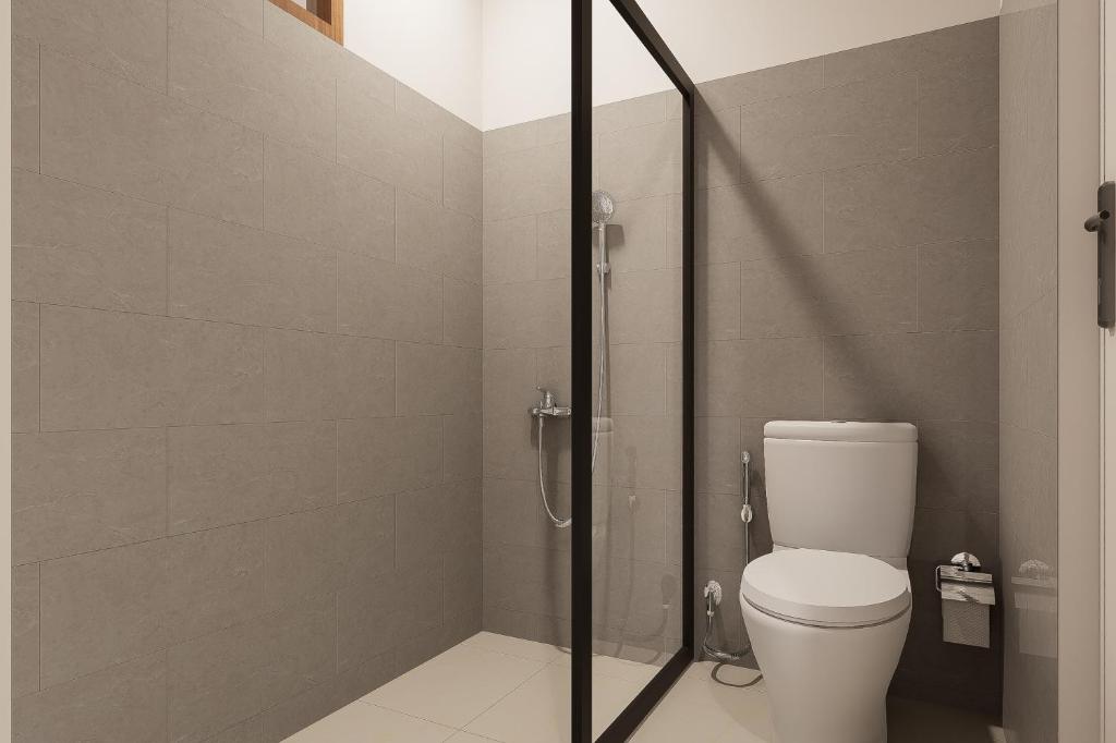 a bathroom with a toilet and a glass shower at Mecutan Guest House in Jimbaran
