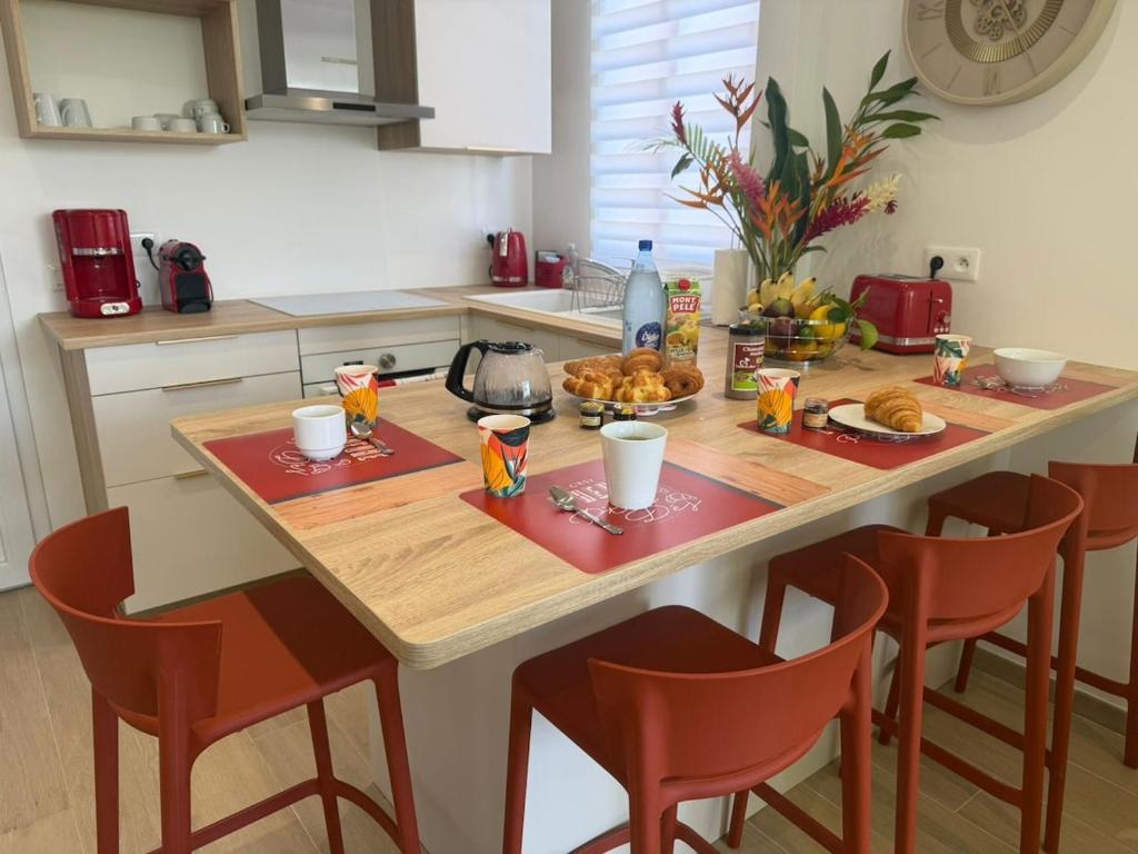 a kitchen with a table with breakfast foods on it at L'Aparté des hibiscus in Les Trois-Îlets