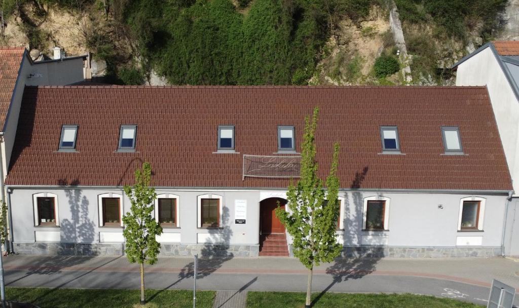 a large white building with a brown roof at Penzion Laskala in Tišnov