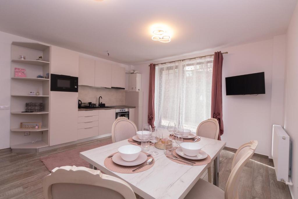 a kitchen and dining room with a white table and chairs at White Valey Retreat One in Buşteni