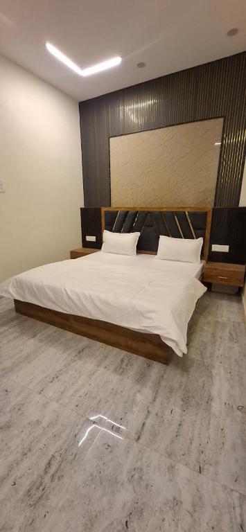 a bedroom with a large bed with a wooden headboard at Keshav Homestay in Varanasi