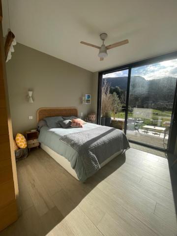 a bedroom with a bed and a large window at 1 Brin à part in Maubec