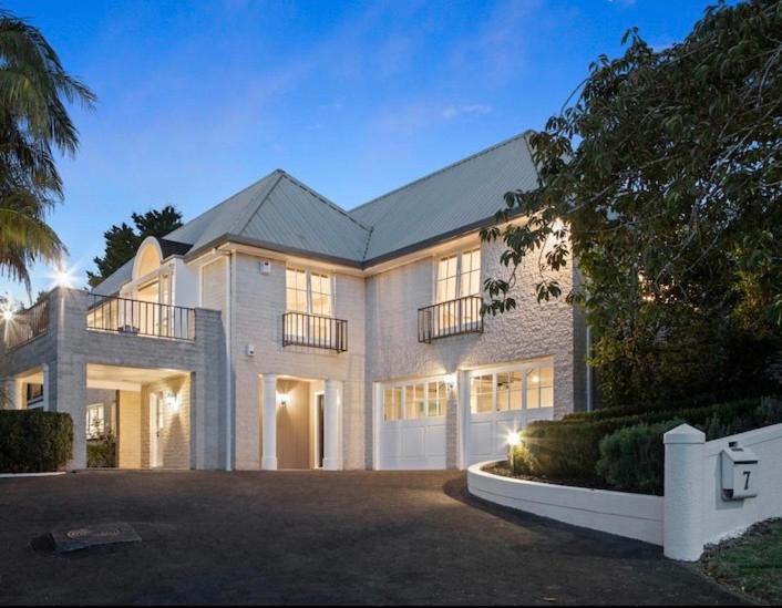 a large white brick house with a garage at Kowhai Apartment-Ground Floor in Pukekohe East