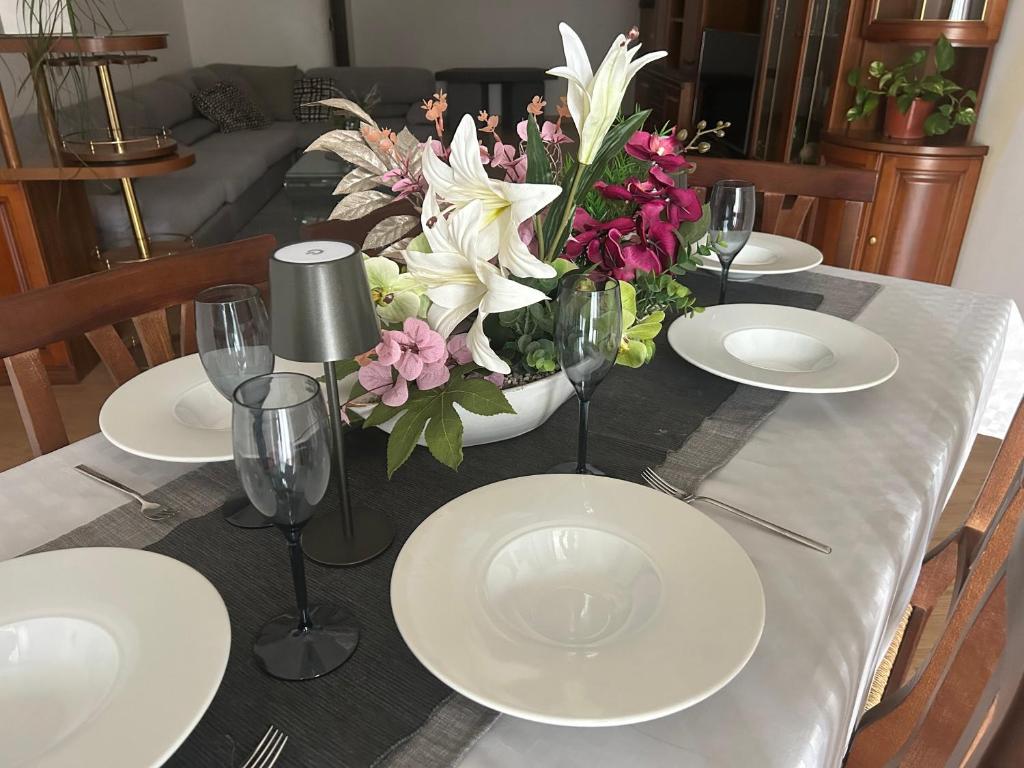 a table with plates and glasses and flowers on it at Lake Garda in Gavardo