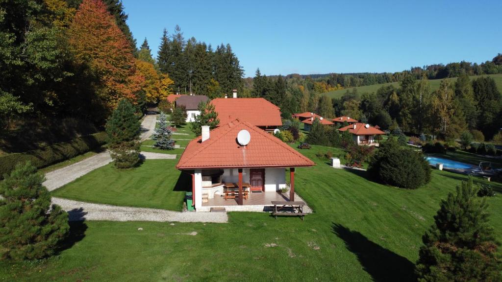 a small house with a red roof on a green field at Motýlek chata Sedmička in Borušov
