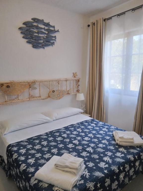 a bedroom with a bed with two towels on it at La Dea Madre in Stintino