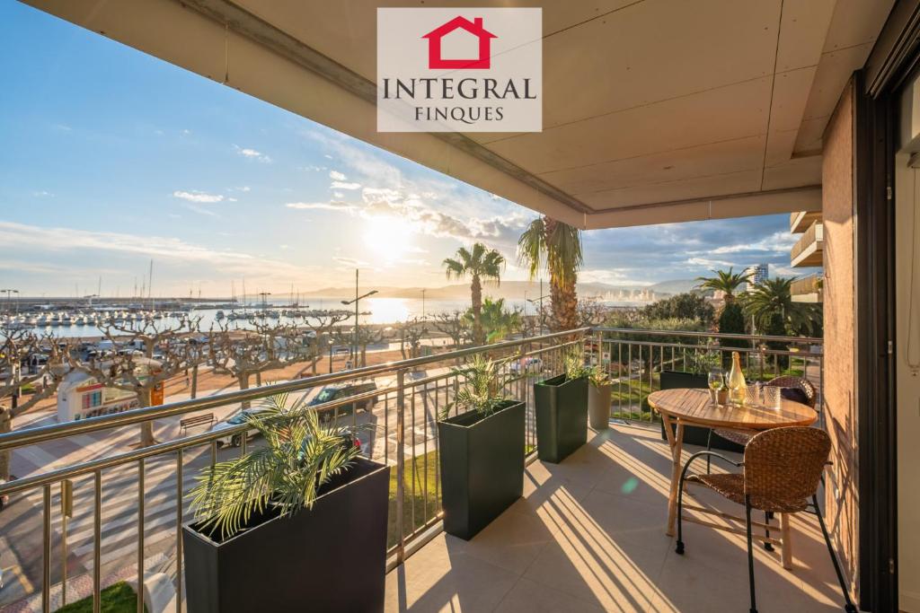 a balcony with a table and chairs and a view of the ocean at Les Palmeres Palamós in Palamós