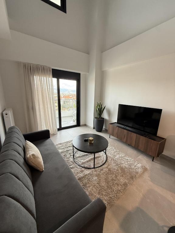 a living room with a couch and a table at Signature city loft in Tríkala