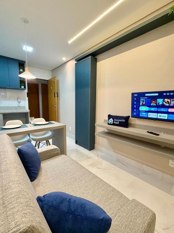 a living room with a couch and a tv on a wall at Studio Atalaia - C -308 - By Hospede Fácil in Brasília