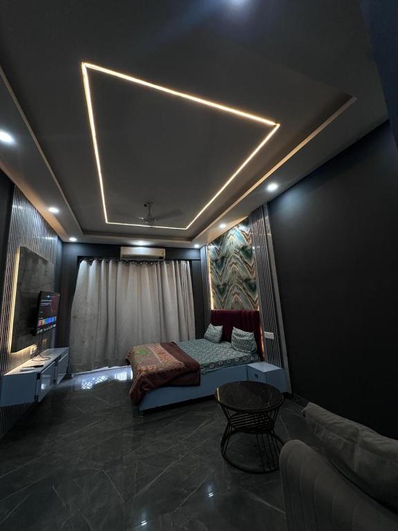 a bedroom with a bed and a couch and a table at Unique property in Ghaziabad
