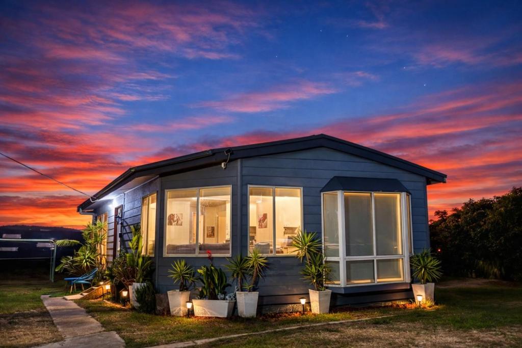 a small house with plants in front of a sunset at Private Farmhouse & Paddock Available in Werribee South