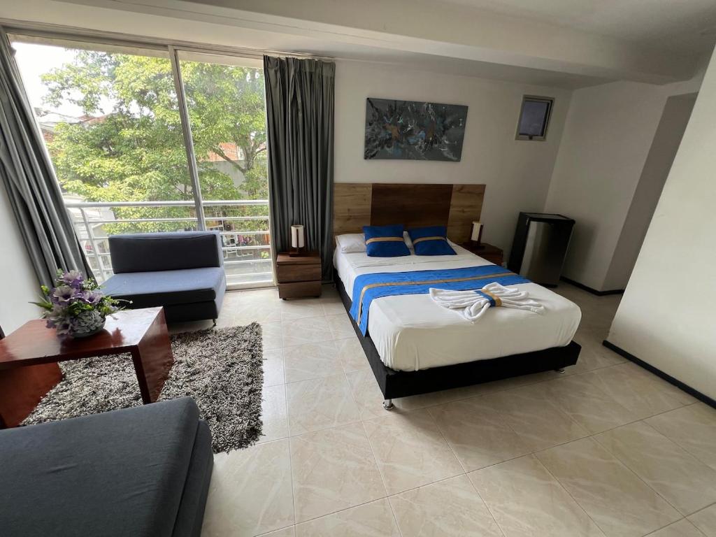 a bedroom with a bed and a couch and a window at Suite de hotel dentro centro comercial in Cartago