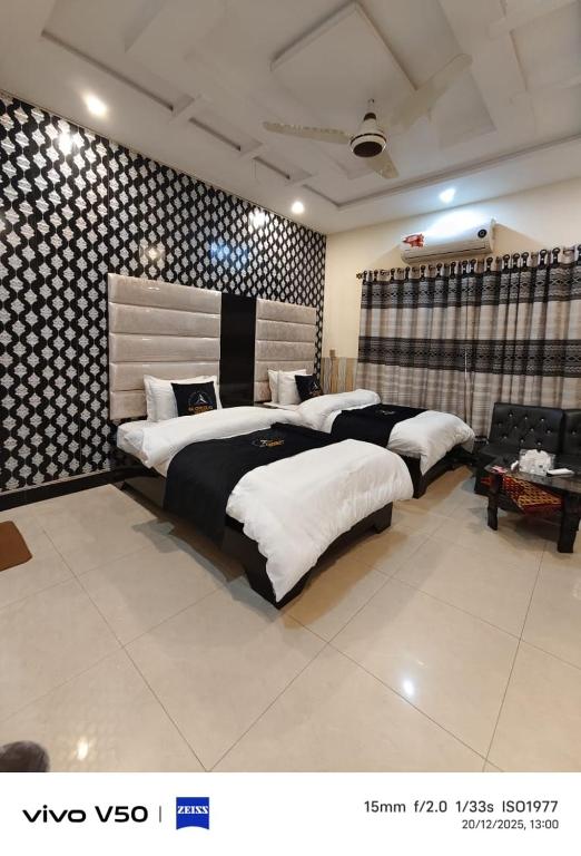 a large bedroom with three beds in it at Glorious Guest House & Hotel in Multan