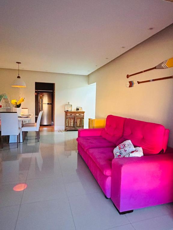a red couch in a living room with a table at Ilha Salinas Canto do Forte in Praia Grande