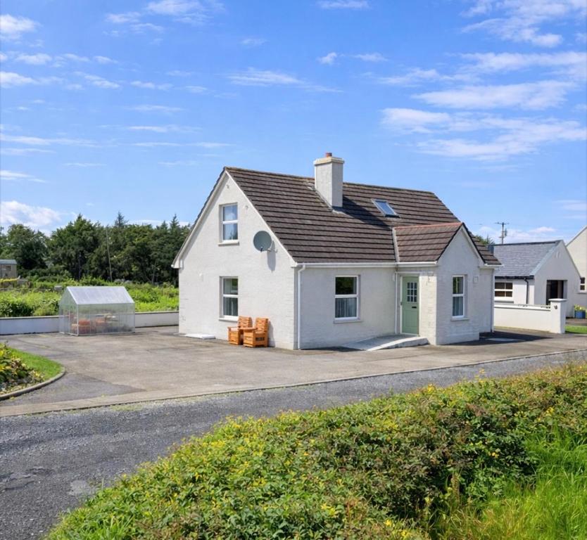 a white house on the side of a road at Sonnys Rest in Ardara