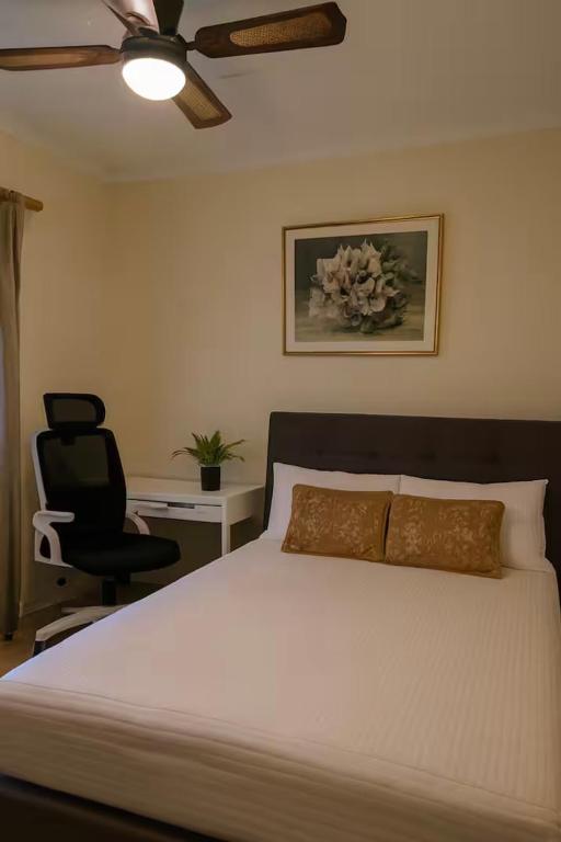 a bedroom with a bed and a desk and a chair at The Haven House in Singleton