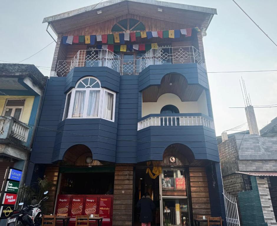 a blue building with a balcony on top of it at Ratnagiri Boutique Hotel in Mirik