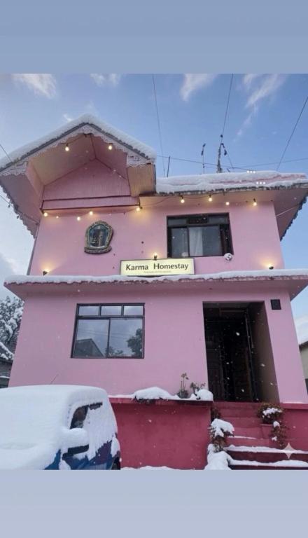 a pink house with snow in front of it at Karma homestay in Ravangla