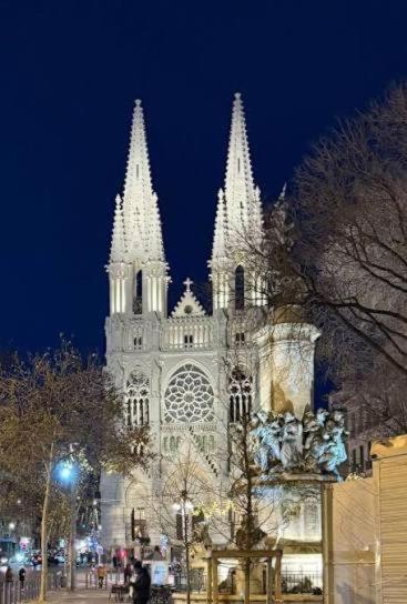 a large cathedral with white towers at night at hôtel des reformés in Marseille