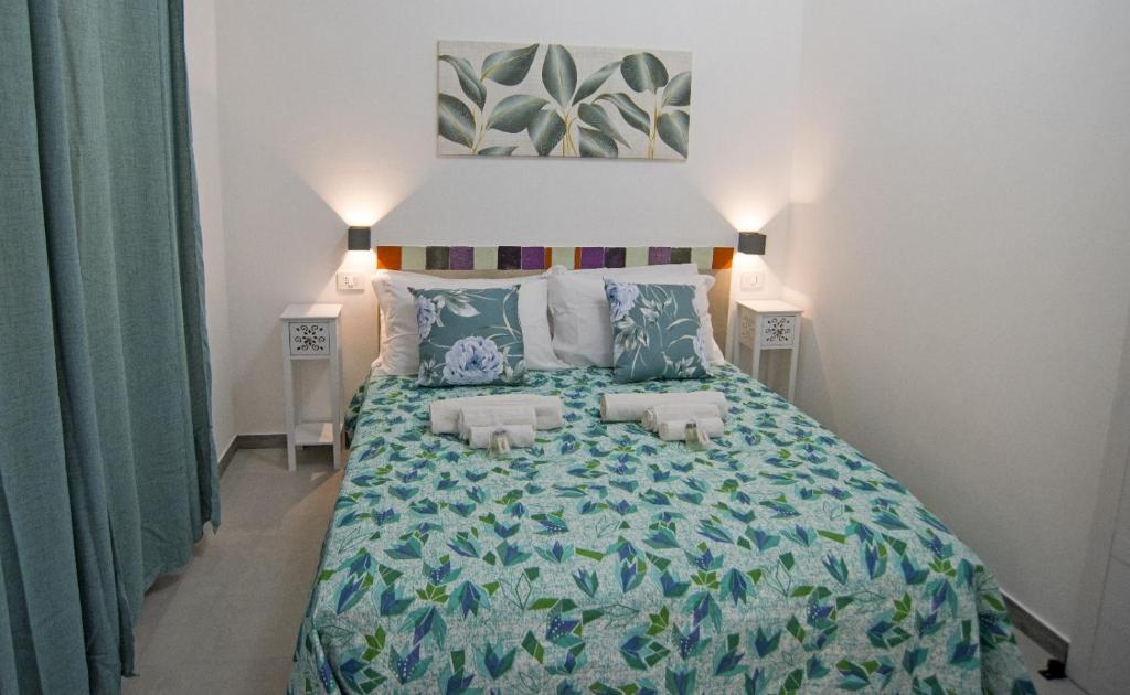 a bedroom with a bed with a green comforter at B&B RoseMary in La Maddalena