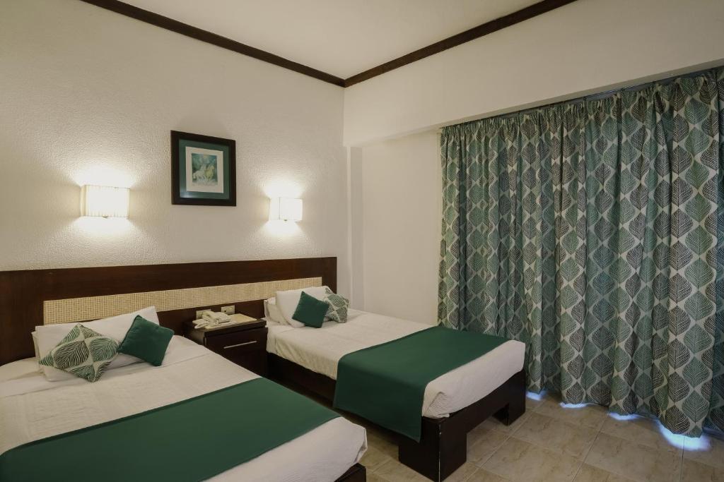 a hotel room with two beds and a window at Beau Site Hotel in Marsa Matruh