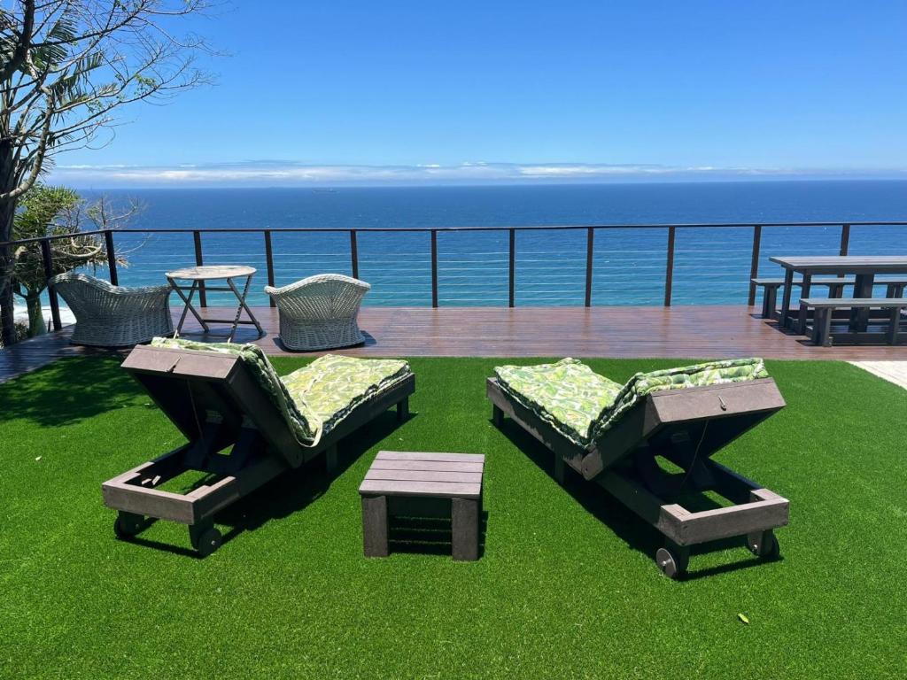 two beds and a table on a field of grass at The Windsock in Ballito