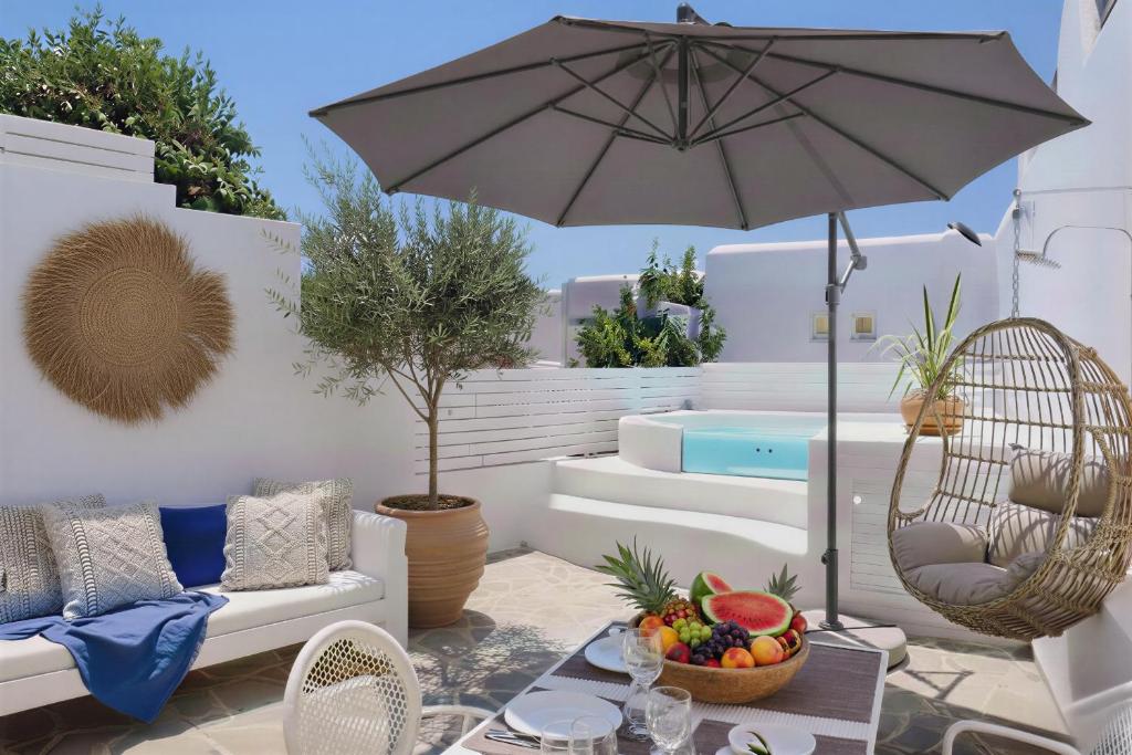 a patio with an umbrella and a table with fruit at Philia Villas in Agkidia