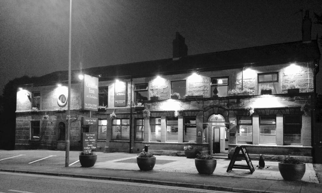 une photo en noir et blanc d'un bâtiment la nuit dans l'établissement The Griffin Inn, à St Helens