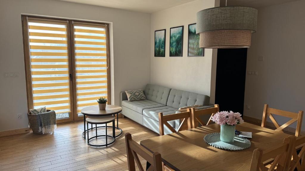 a living room with a couch and a table at Apartamenty Polna Ostoja in Tylicz