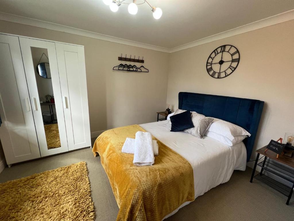 a bedroom with a bed and a clock on the wall at Riverview Colchester in Colchester