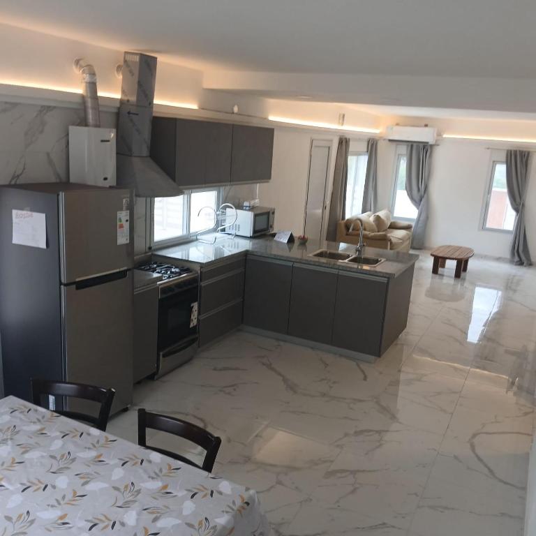 a kitchen with a table and a kitchen with a refrigerator at Ein gutes Haus in Mina Clavero