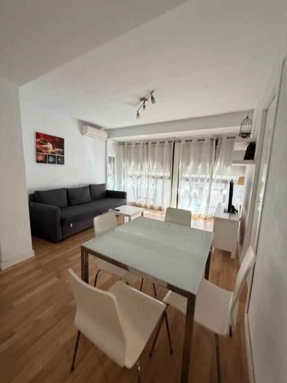a dining room and living room with a table and chairs at Zerka Centro in Valencia